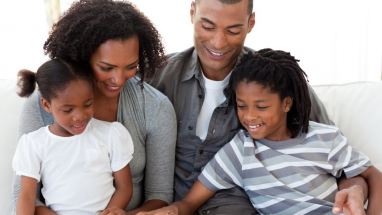 family of four reading a book together