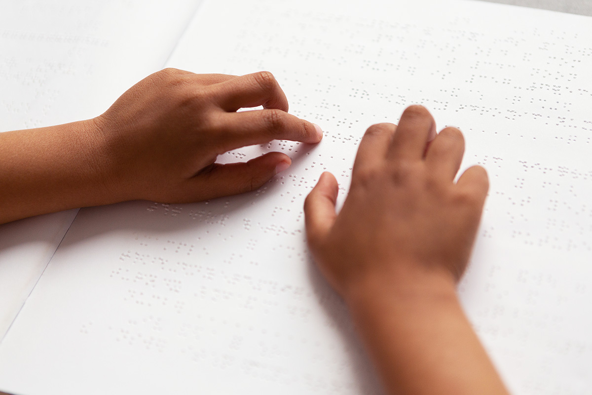 Child reading page with Braille