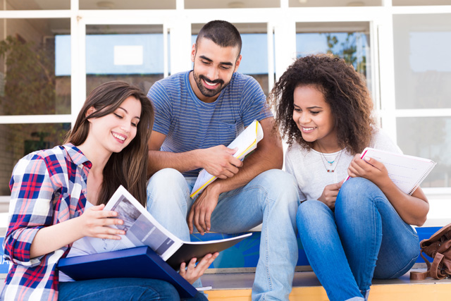 group of students sitting on steps on college campus