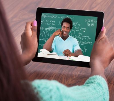 Student holding an ipad showing a picture of a teacher