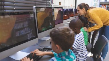 Teacher working with students at computers