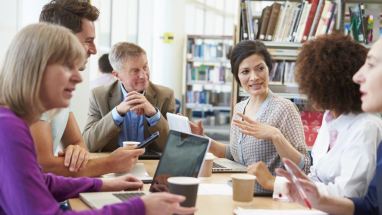 Adult educators collaborating around a table